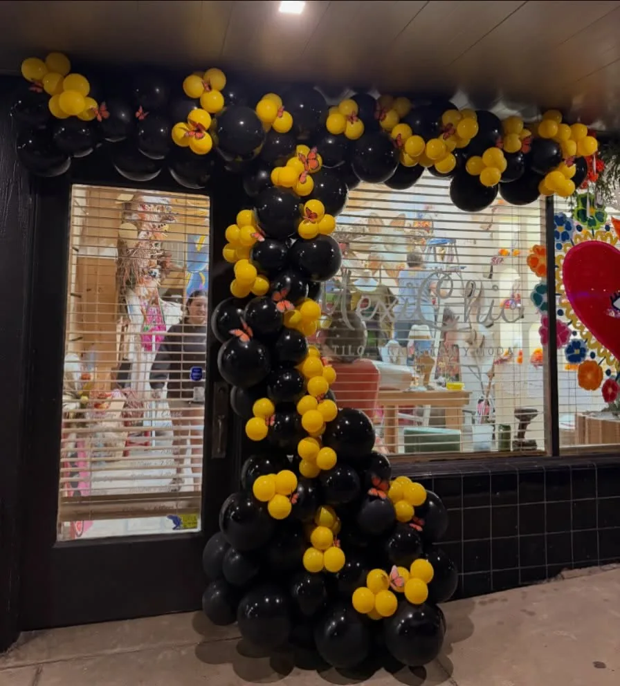 Black and yellow balloon installation with butterfly accents